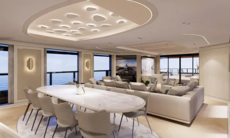 Betsy: Dining table with chairs beside a lounge area and windows overlooking the sea
