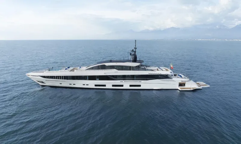 Betsy: White yacht at sea in side profile with mountains on the horizon
