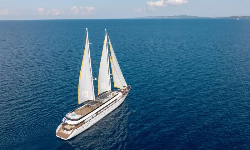 Anima Maris: Aerial view of a sailing yacht with sails raised on deep blue open sea