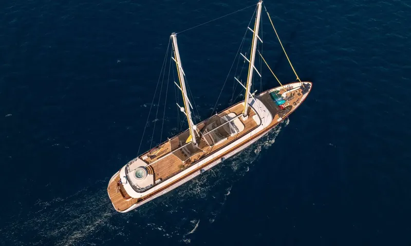 Anima Maris: Two masted yacht under way on deep blue sea seen from above, teak decks visible