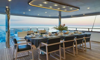 Anima Maris: Outdoor dining table set for dinner on a covered teak deck at dusk with sea views