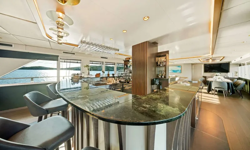 Anima Maris: Green stone bar counter with stools overlooking the sea through side windows