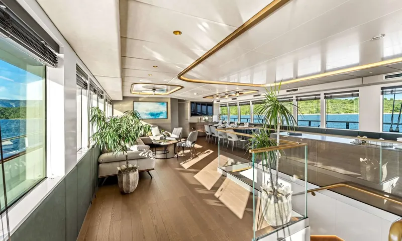 Anima Maris: Open plan saloon with lounge seating, dining area and glass staircase railing