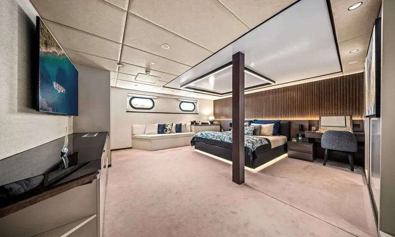 Anima Maris: Cabin with a double bed, sofa under portholes, desk and wall screen