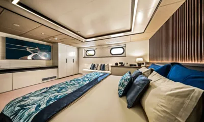 Anima Maris: Wide cabin with large double bed, blue cushions, wardrobe, wall artwork and two portholes
