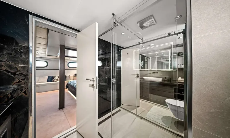Anima Maris: Ensuite with glass shower, vessel sink and dark marble walls, door open to the cabin