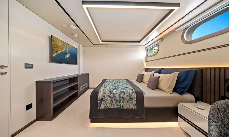 Anima Maris: Double cabin with patterned bedspread, wall screen, low sideboard and portholes