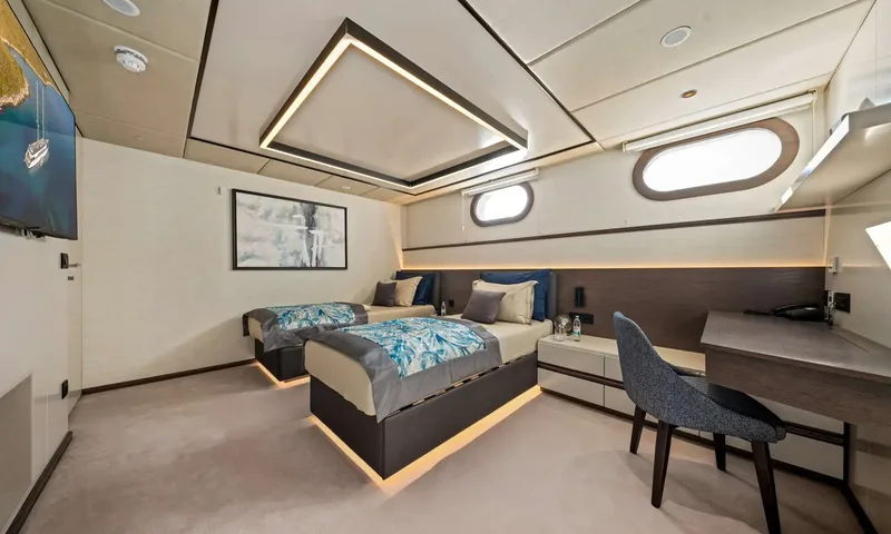 Anima Maris: Twin cabin with two underlit single beds, desk with chair and two portholes