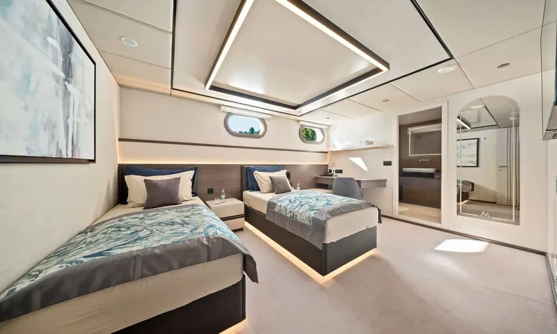 Anima Maris: Twin cabin with two single beds, artwork, arched mirror and open ensuite door
