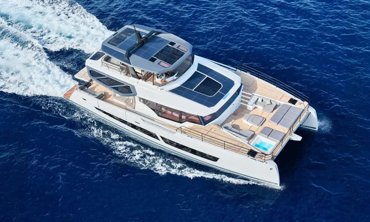 Alina: Aerial view of a white power catamaran cruising on deep blue sea with foredeck jacuzzi and sunpads
