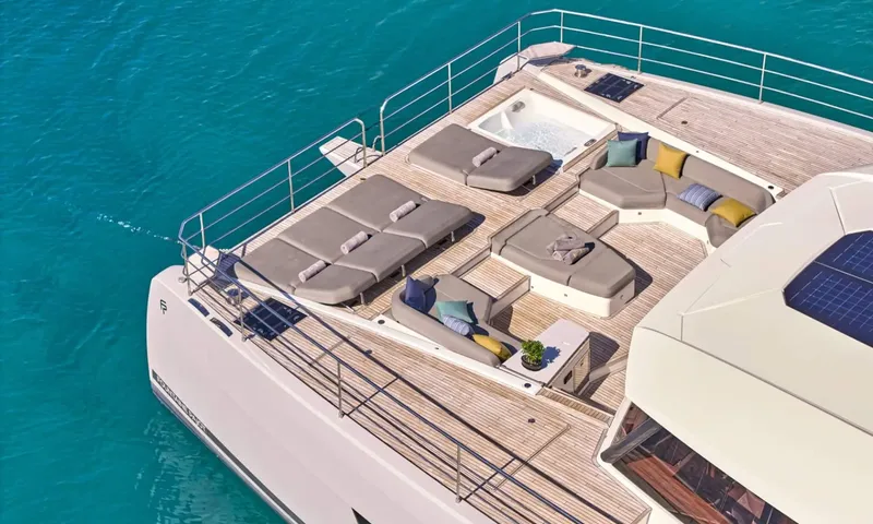 Alina: Elevated view of foredeck with sunpads, lounge sofas and jacuzzi above turquoise water