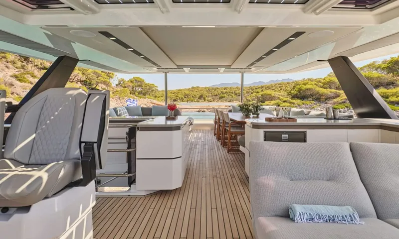 Alina: Shaded top deck with helm seat, bar counters, dining table and sofa overlooking wooded hills
