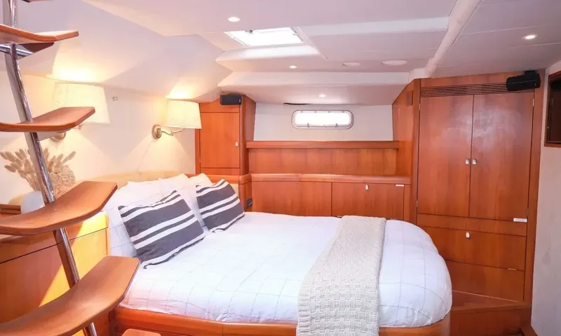 Crazy H: Cabin with double bed, striped pillows, wooden wardrobe and wall lamp
