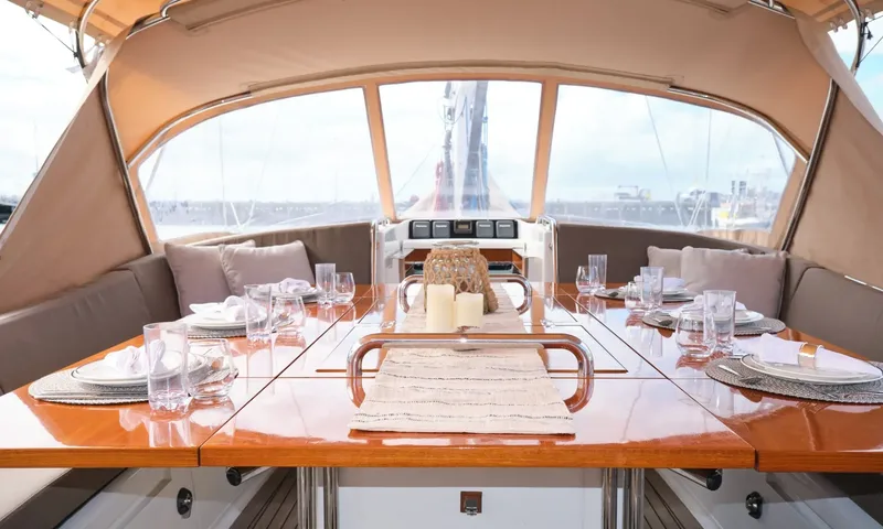 Crazy H: Cockpit table set for dinner with glasses and candles under a canvas enclosure