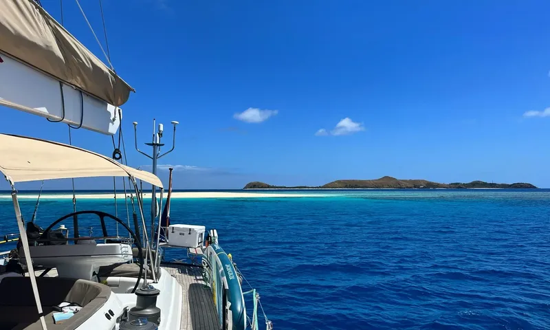 Crazy H: View from the cockpit with twin helm wheels toward turquoise sea, sandbar and island