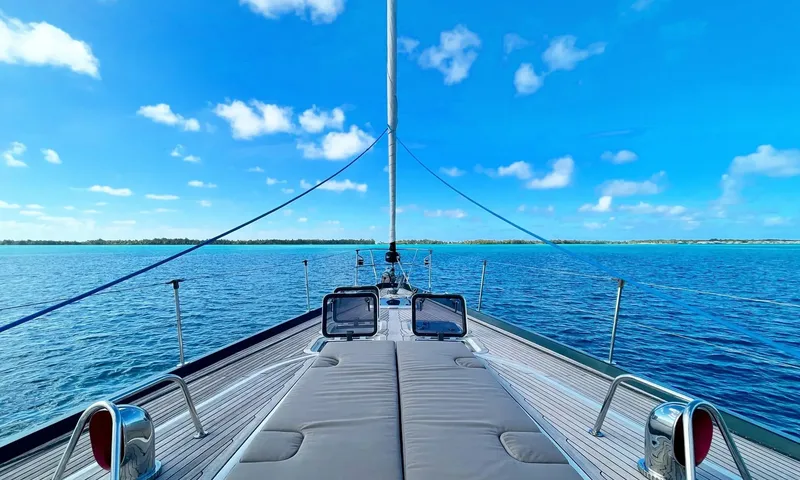 Crazy H: Foredeck sunpads with teak deck facing a calm blue lagoon
