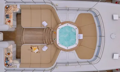 Isabell Princess of the Sea: Overhead view of a top deck jacuzzi surrounded by beige sunpads and curved seating
