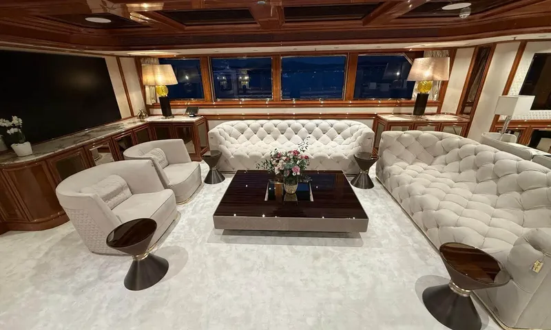 Isabell Princess of the Sea: Lounge with tufted cream sofas, armchairs, a dark coffee table and a large screen
