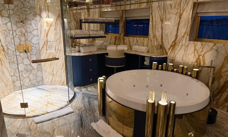 Isabell Princess of the Sea: Marble bathroom with round whirlpool tub, glass shower and vanity with folded towels