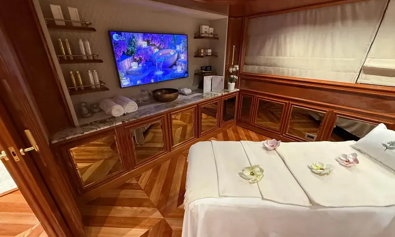 Isabell Princess of the Sea: Massage room with treatment table decorated with flowers, wall screen and wood cabinets