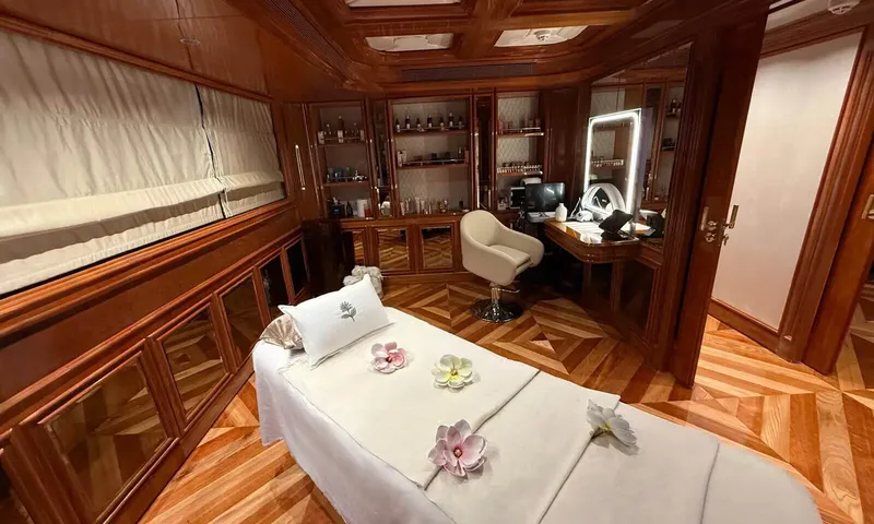 Isabell Princess of the Sea: Treatment room with massage table, salon chair and lit mirror on parquet floor