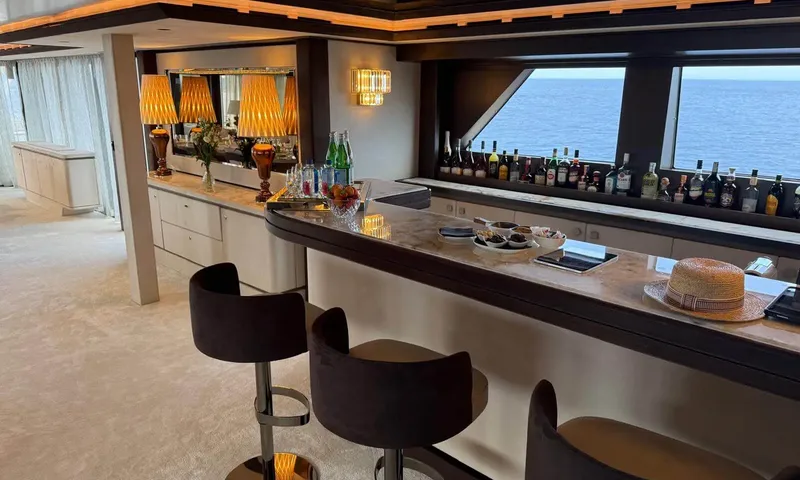Isabell Princess of the Sea: Bar counter with dark stools, bottles lined along windows overlooking the sea