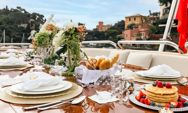 Isabell Princess of the Sea: Breakfast table with pancakes, berries, bread and flowers on deck facing a colorful harbor town