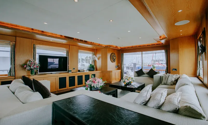 Indiana: Saloon with white sofas, dark coffee tables, flowers, wood panelling and a television