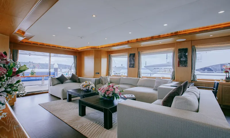 Indiana: Bright saloon with large windows, white sectional sofas and glass doors to the aft deck