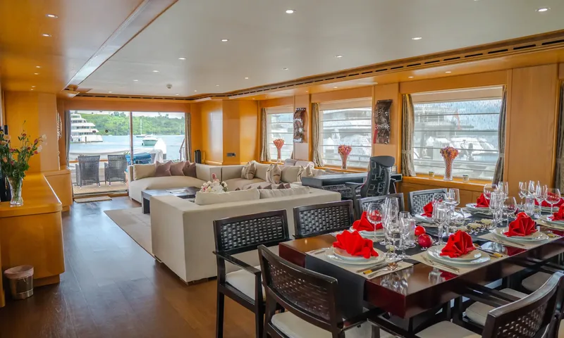 Indiana: Dining table set with red napkins and glasses beside a lounge with sofas