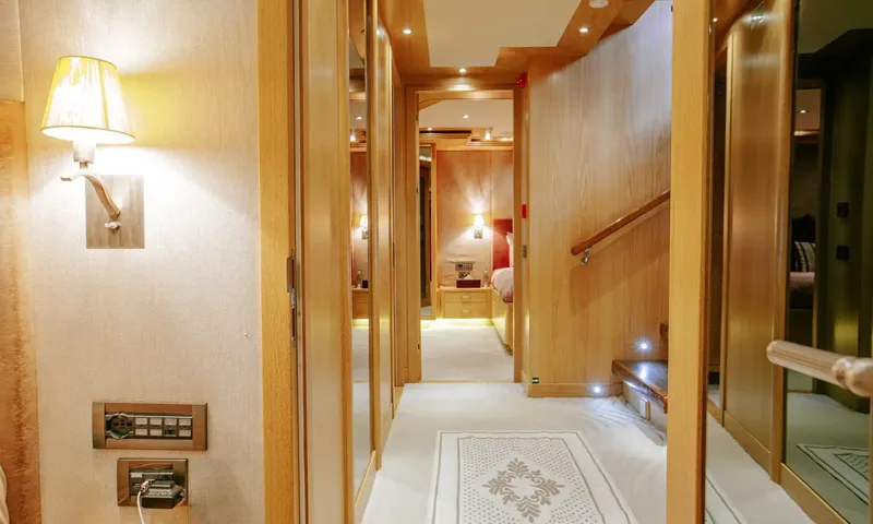Indiana: Wood panelled corridor with a stairway leading to lit cabins