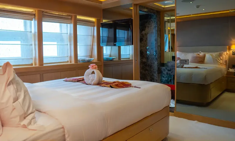 Indiana: Double bed with a towel swan, windows, television and a mirror reflecting the room