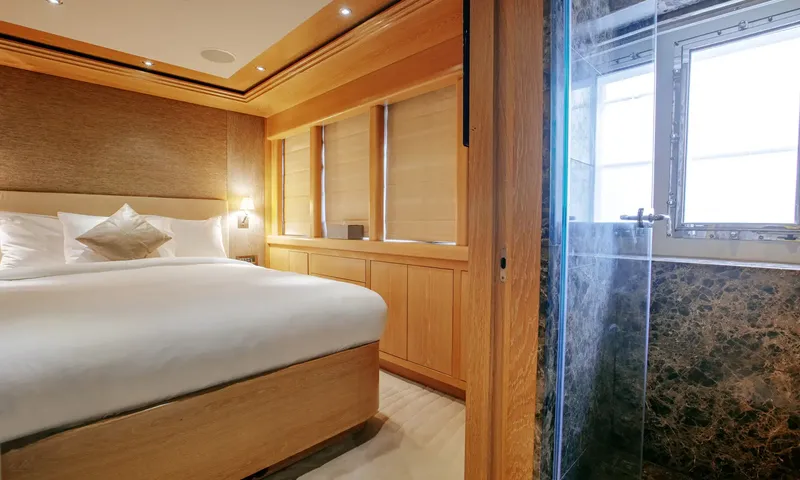 Indiana: Cabin with double bed and wood cabinetry next to a dark marble shower