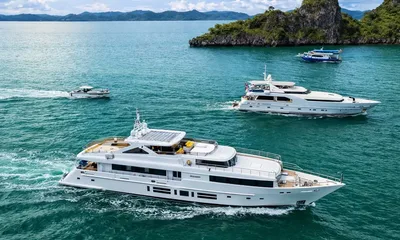 Indiana: Aerial view of a white yacht under way with another yacht and small boats near an island