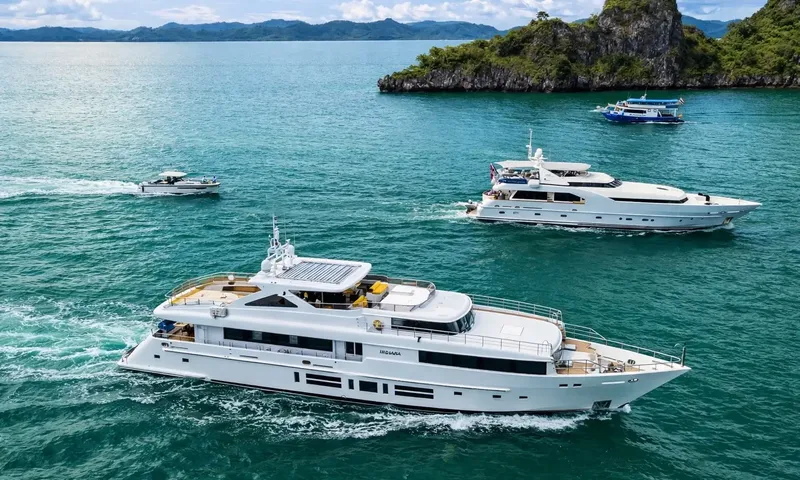 Indiana: Aerial view of a white yacht under way with another yacht and small boats near an island