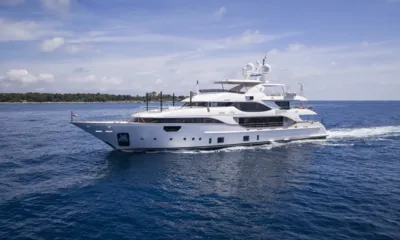 Nela: White yacht cruising at speed on deep blue sea under a bright sky