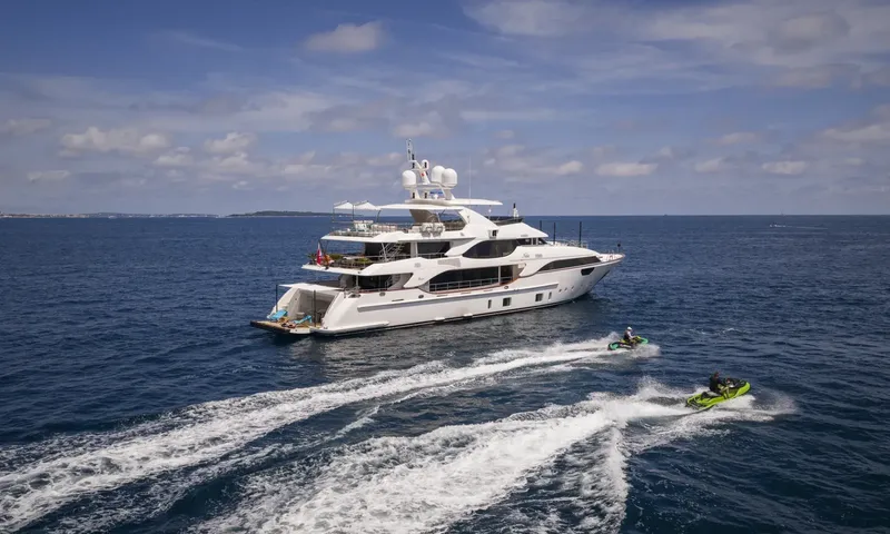 Nela: Yacht at sea viewed from above with two jet skis leaving white wakes