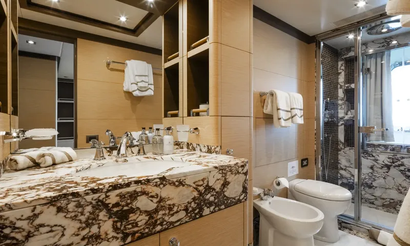 Nela: Ensuite with brown veined marble vanity, glass shower, toilet and bidet