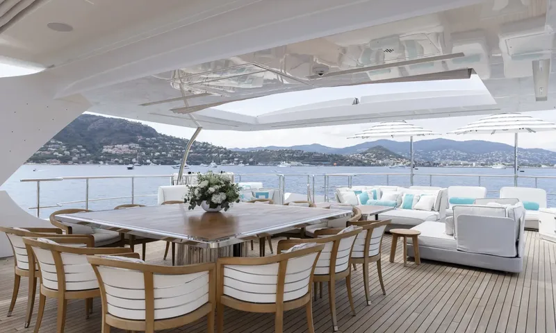 Nela: Large outdoor dining table with flowers and chairs beside a lounge facing the bay
