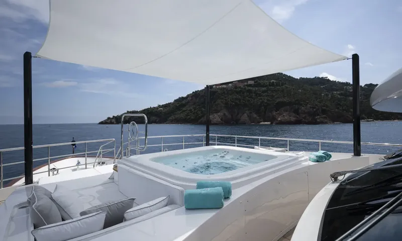 Nela: Jacuzzi under a white shade sail with cushions and sea and headland view