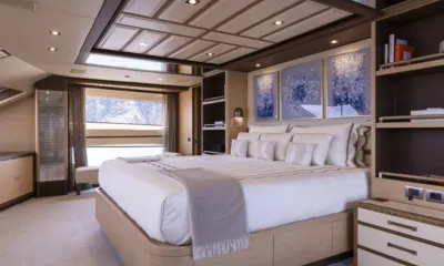 Nela: Main cabin with large bed, blue artworks above, bookshelves and wide window
