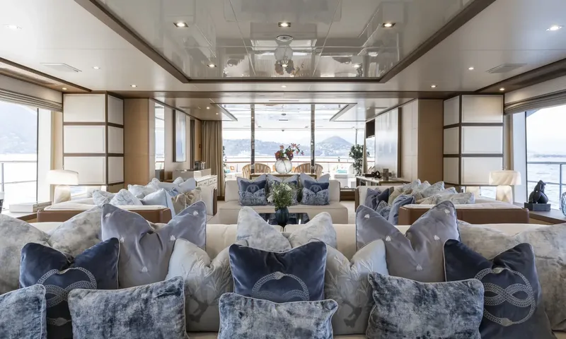 Nela: Symmetrical saloon with velvet cushions on sofas leading to dining area and aft view