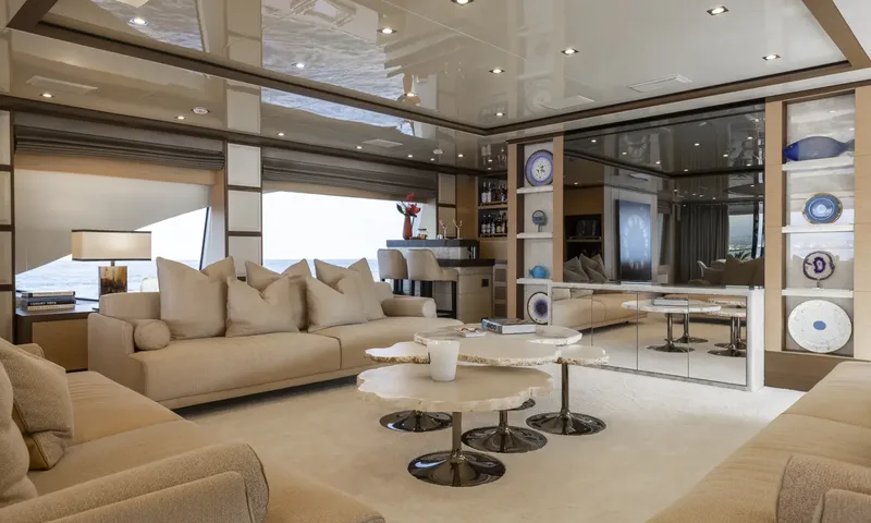 Nela: Beige lounge with sofas, layered round coffee tables, bar stools and decorative plates