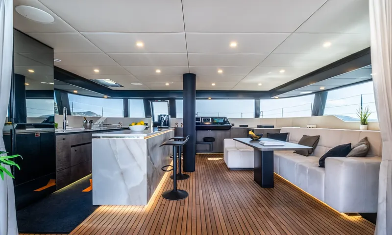 YGO: Bright saloon with marble kitchen island, bar stools, white sofa and wraparound windows