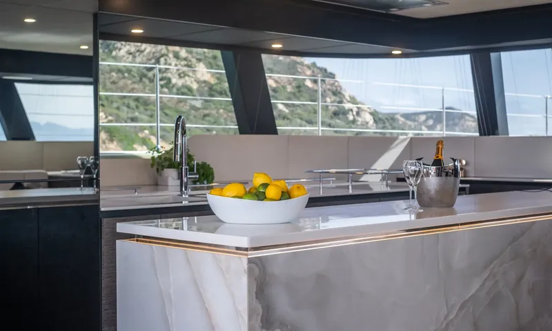 YGO: Marble kitchen island with a bowl of lemons and limes and a chilled bottle