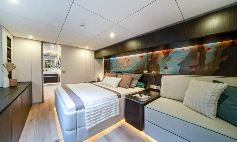 Hu-Lysse: Double cabin with lit artwork above the bed, sofa and open door to the bathroom