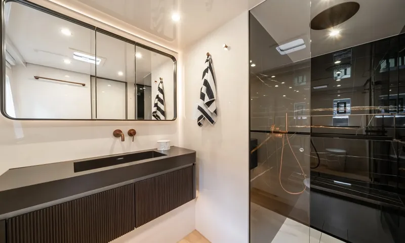 Hu-Lysse: Ensuite with dark vanity, copper taps, wide mirror and glass walk in shower