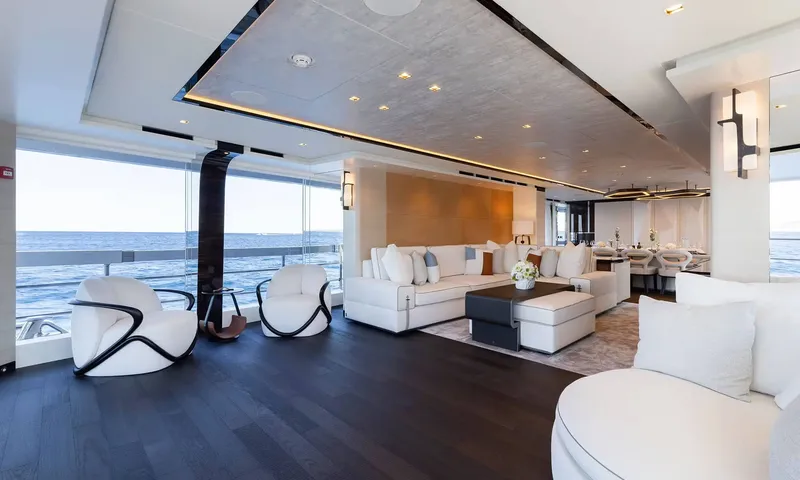 Orion: Bright saloon with white sofas, armchairs and large windows facing the sea