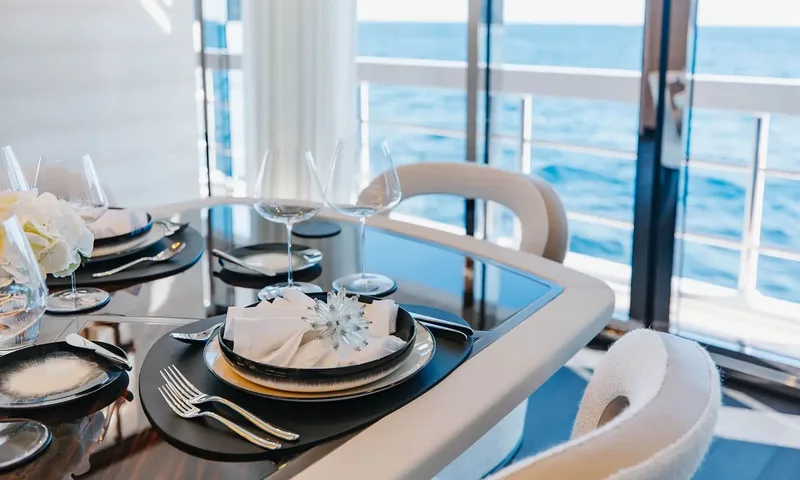 Orion: Close view of a table setting with glasses, folded napkin and sea view