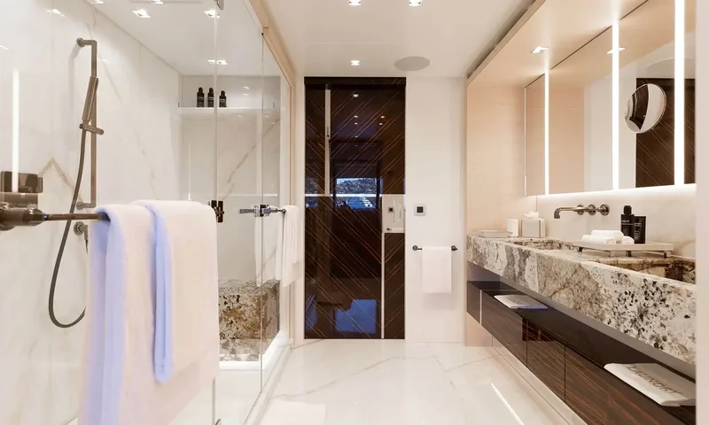 Orion: Marble bathroom with walk in shower, stone vanity and dark wood door